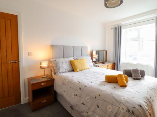 a bedroom with a large bed with yellow pillows on it at Arnant in Dolgellau