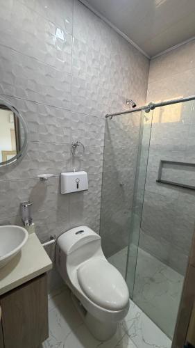 a bathroom with a toilet and a glass shower at Serenity House in Santa Marta