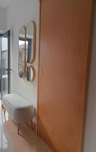 a wooden door with a chair and a mirror at Casa do beco Martinho in Viana do Castelo