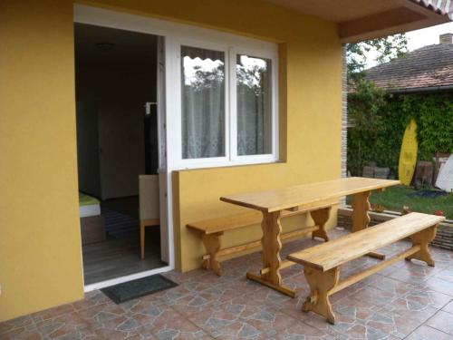 two wooden benches sitting outside of a house at Studios near Beach in Balatonfoeldvar 18525 in Balatonföldvár
