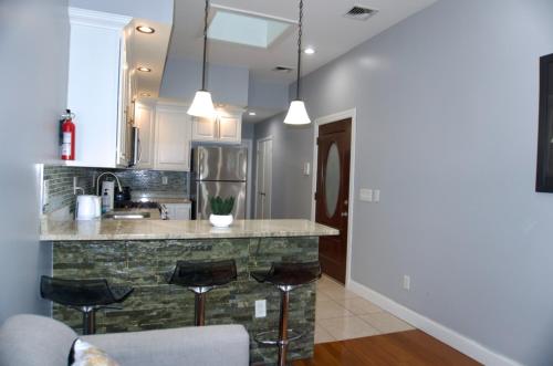 a kitchen with a stone counter and stools at New York Private room 30 in West New York