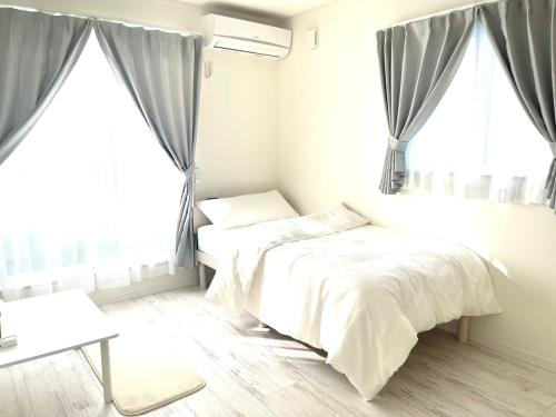 a bedroom with two beds in front of windows at Sunny Inn Sumida in Tokyo