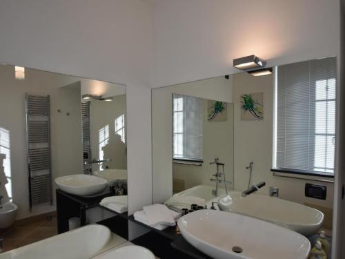 a bathroom with three sinks and two mirrors at Villa with Panoramic Views for 6 in Oggebbio