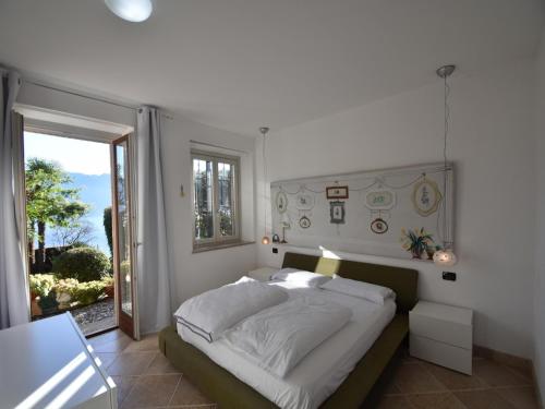 a bedroom with a bed and a window and a door at Villa with Panoramic Views for 6 in Oggebbio