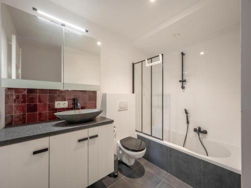 a bathroom with a sink and a toilet and a tub at Knokke City Centre Apartment for 6 in Knokke-Heist