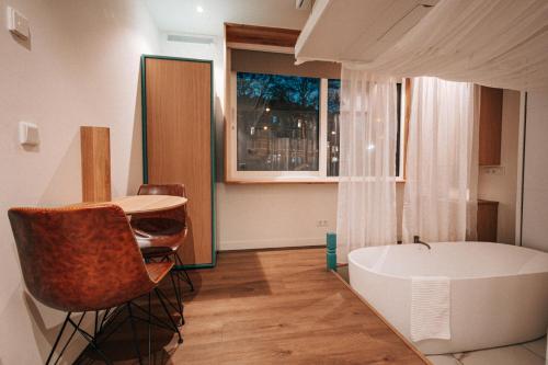 a bathroom with a tub and a table and chairs at The Amsterdam Houseboat Family - de Jordaan Brand New Houseboat! in Amsterdam