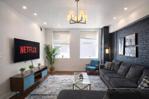a living room with a couch and a tv at Stylish Cozy 3BR 420 Friendly Apartment with Gym Near McCormick Place, Grant Park and Soldier Field in Chicago