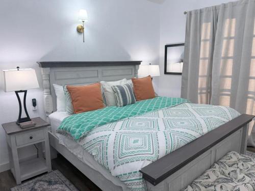 a bedroom with a bed with a green and white comforter at The House Next Door in Calliaqua