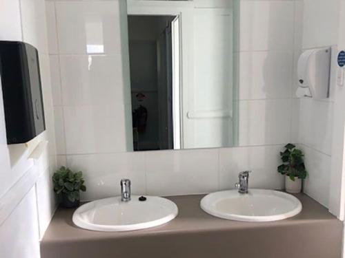 a bathroom with two sinks and a large mirror at white hart hotel murrurundi in Murrurundi