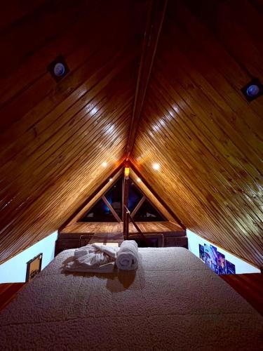 a room with a bed in a wooden ceiling at Chalé Sertão da Boa Vista in Rio Claro
