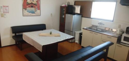 a small kitchen with a table and a refrigerator at 桜庵 sakura an in Hatsukaichi