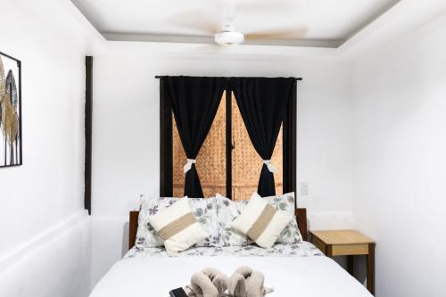 a bedroom with a bed with black curtains at Trisha Guesthouse in San Vicente
