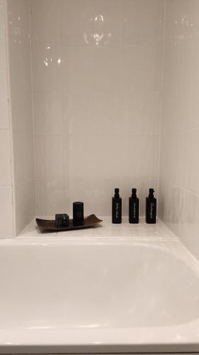 four black bottles sitting on a shelf in a room at Urban Retreat - Leeds City Centre - Sleeps 4 in Central Station