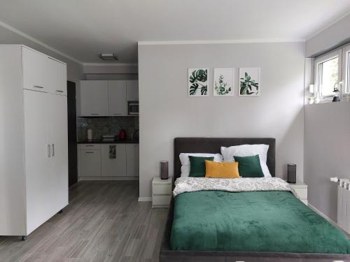 a bedroom with a bed with green and yellow pillows at Villa6 in Pobierowo