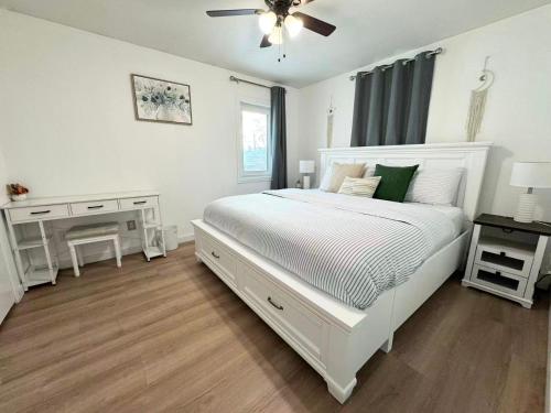 a white bedroom with a white bed and a desk at Cozy Stay Retreat in Fairbanks