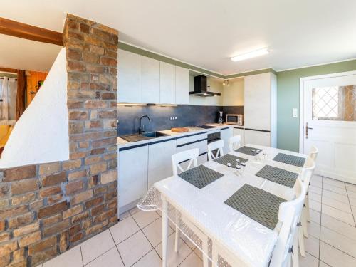 eine Küche mit einem Tisch und einer Backsteinwand in der Unterkunft Modern Holiday Home in Lavacherie in Sainte-Ode