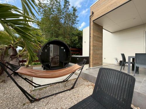 a hammock on the patio of a house at Villa SUN58 ヴィラサンゴエイト in Miyako-jima