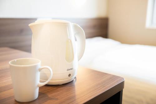 a coffee maker and a cup on a table at Super Hotel Kumamoto Ekimae Natural Hot Springs in Kumamoto