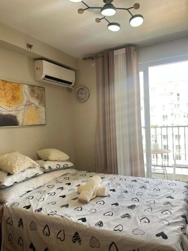 a bedroom with a bed and a window at Gold-Themed Condo with Balcony and FREE Pool Access in Suba