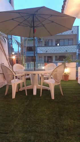 a white table and chairs under an umbrella at terraza y balcón en la zona romantica cerca del mar in Puerto Vallarta