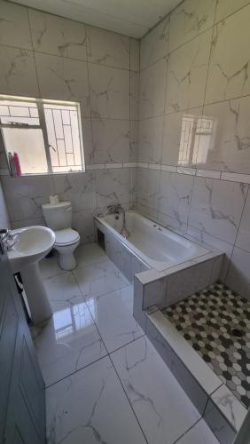 a bathroom with a tub and a toilet and a sink at 124 On Comet Oaks in Boksburg