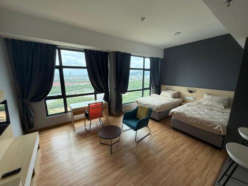 a bedroom with two beds and chairs and windows at Swiss Cozy Studio Kuantan City View Imperium Residence in Kuantan