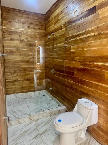 a bathroom with a toilet and a glass shower at Villa Republik in Parrita