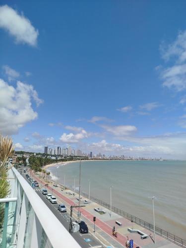a view of the beach from the balcony of a building at Flat Praia Cabo Branco João Pessoa in João Pessoa