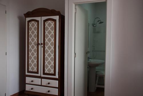 uma casa de banho com um armário de madeira e um lavatório em Hotel - Restaurante Estación Vía Verde em Olvera