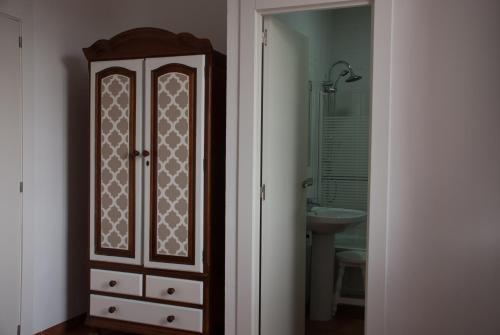y baño con armario de madera y lavabo. en Hostal- Restaurante Estación Vía Verde, en Olvera