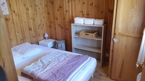 a bedroom with a bed and a wooden wall at Camping La Motte Flottante in La Freissinouse
