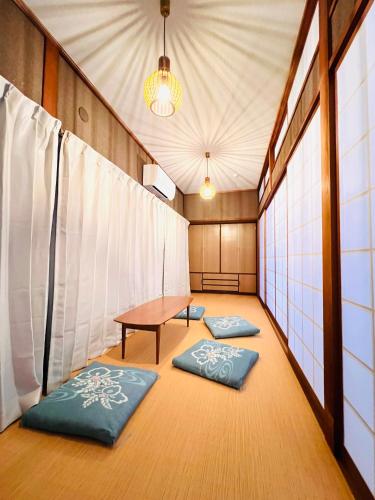 a room with a table and two meditation mats at 2025年12月OPEN! 豊橋民泊 最大13名様 駐車場2台無料 駅徒歩7分 Traditional Japanese house ,Toyohashi Aichi in Toyohashi