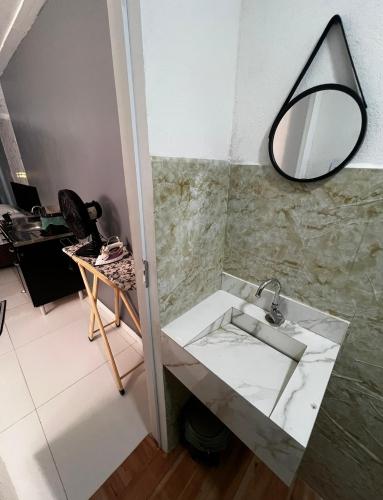 a bathroom with a sink and a mirror on the wall at Studio 94 in Parauapebas