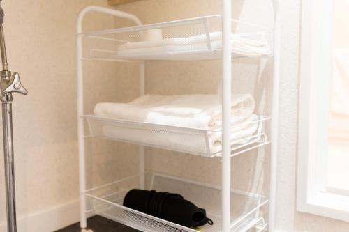 a white towel rack in a room with towels at Miro Hotel Dotonbori in Osaka