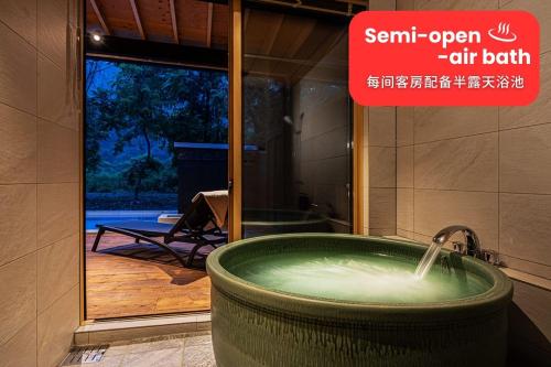 a hot tub in a bathroom with a sign that readstemp open air bath at 秩父別邸 木叢 komura in Chichibu