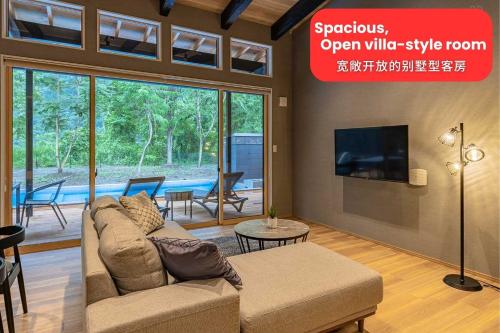a living room with a couch and a flat screen tv at 秩父別邸 木叢 komura in Chichibu