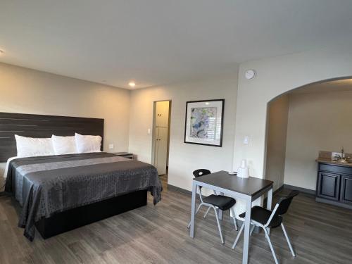 a hotel room with a bed and a table at Cloud 9 Inn - El Ciello Inn in Pico Rivera