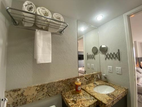 a bathroom with a sink and a mirror at Natal Plaza Hotel in Natal