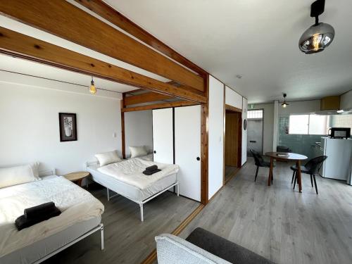 a bedroom with two beds and a living room at House 1956 in Itoman