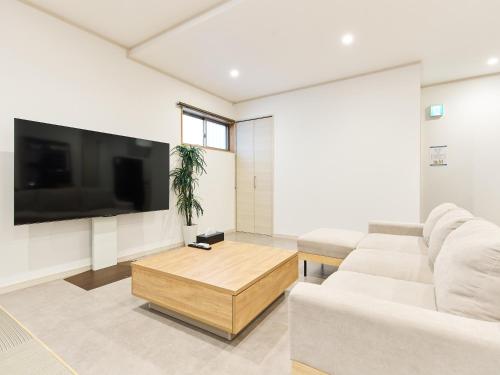 a living room with a couch and a tv at マーケットステイ串本 MarketStay Kusimoto in Kushimoto