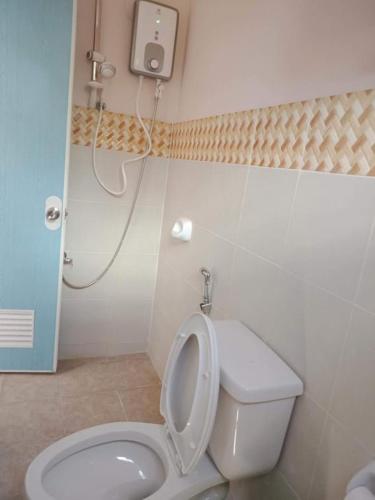 a bathroom with a white toilet and a shower at Villareal Homestay in Coron