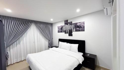 een slaapkamer met een bed en twee schilderijen aan de muur bij Realistic Homes in Accra