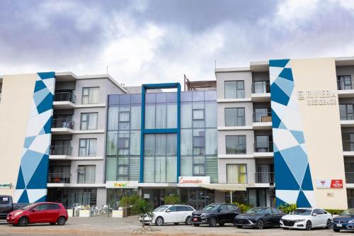 un edificio con auto parcheggiate di fronte di Realistic Homes a Accra