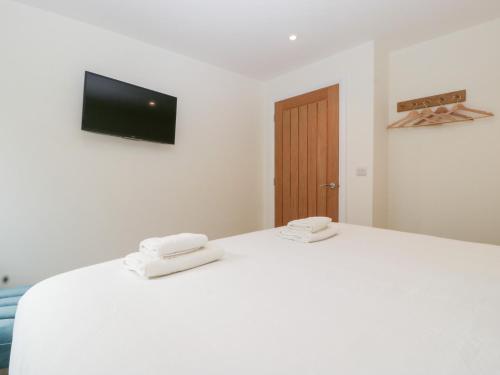a white bed with two towels on top of it at Hidden Well in Bristol