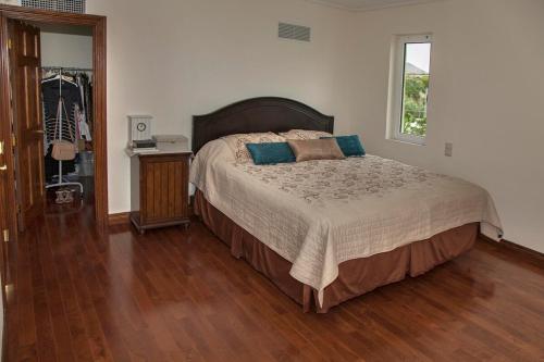 a bedroom with a large bed and a wooden floor at Lagonisi Beach Villa in Lagonissi