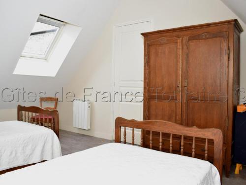 a bedroom with two beds and a wooden cabinet at Maison tourangelle restaurée, 3 chambres, jardin clos, village viticole, proche loisirs et équipements bébé - FR-1-381-236 in Restigné