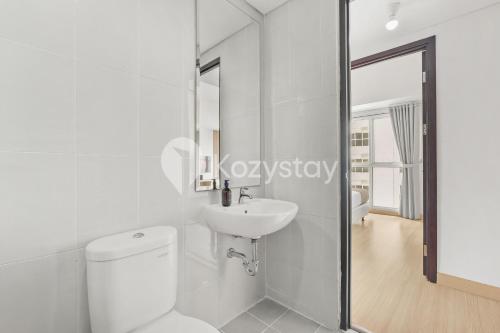 a white bathroom with a toilet and a sink at Elion by Kozystay - BSD in Samporo