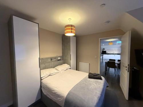 a bedroom with a bed and a dining room at Magna House in Egham