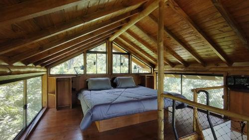 a bed in the middle of a room with windows at Floresta Mandaçaia in São Roque