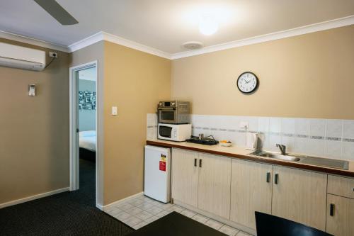 a kitchen with a refrigerator and a clock on the wall at Grandis 35 in Albany